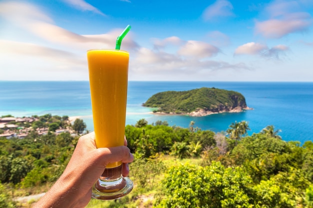 Hand holding glass of juice on Koh Phangan island, Thailand