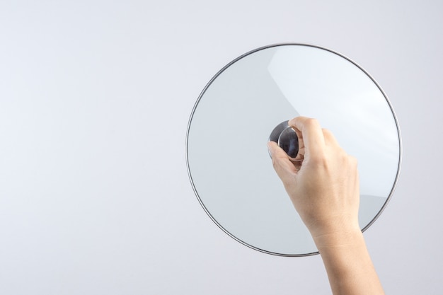 Hand holding glass lid for pan or pot