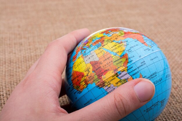 Photo hand holding a globe on canvas