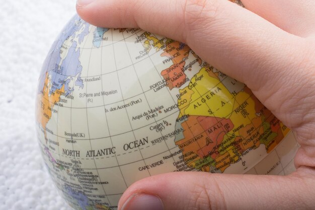 Hand holding a globe with the map on it