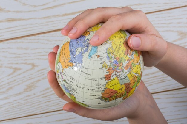 Hand holding a globe with the map on it