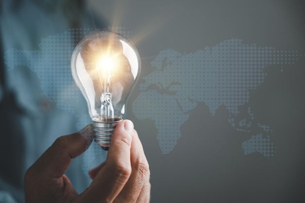 A hand holding a glowing light bulb signifying the connection between creative ideas