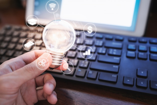 Hand holding glowing light bulb