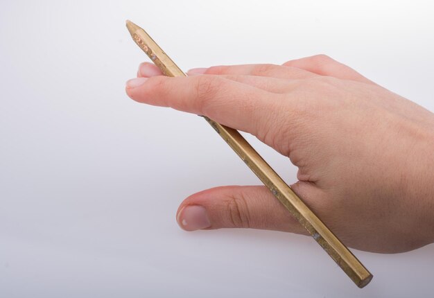 Hand holding a gold color pencil in hand