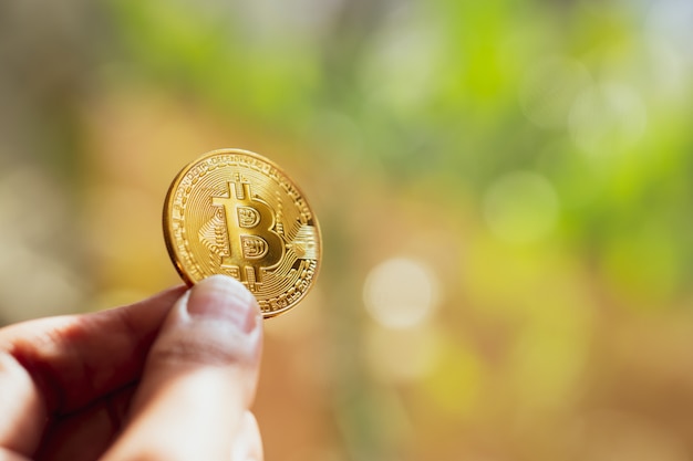 Photo hand holding a golden bitcoin