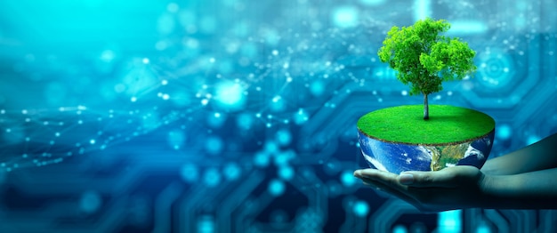 エコテクノロジーとテクノロジーコンバージェンスで成長する木と地球の手持ちの柄グリーンコンピューティンググリーンテクノロジーグリーンITcsrとIT倫理コンセプト画像NASA提供