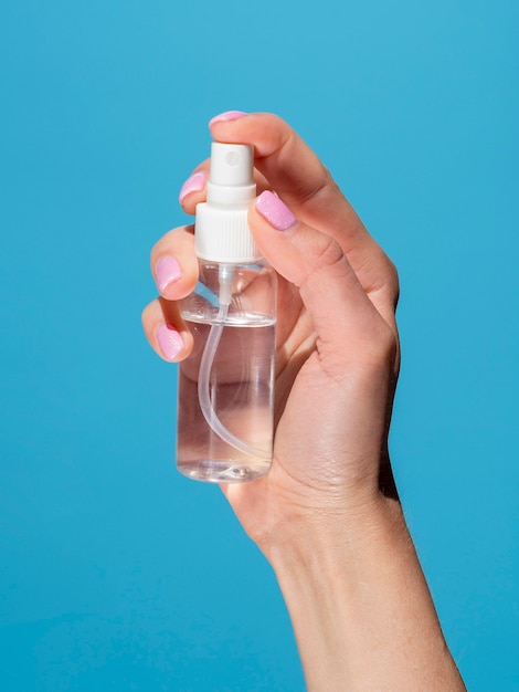 Photo hand holding hand sanitizer bottle