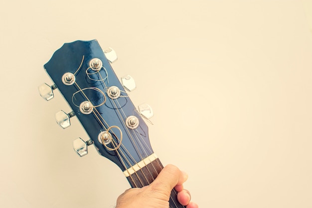 Photo hand holding headstock of guitar