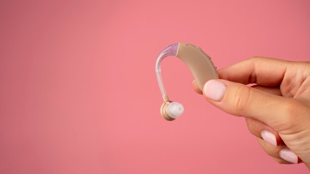 Photo hand holding hearing aids side view