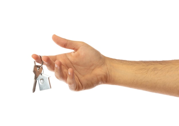 Hand holding a house key isolated on white background clipping path