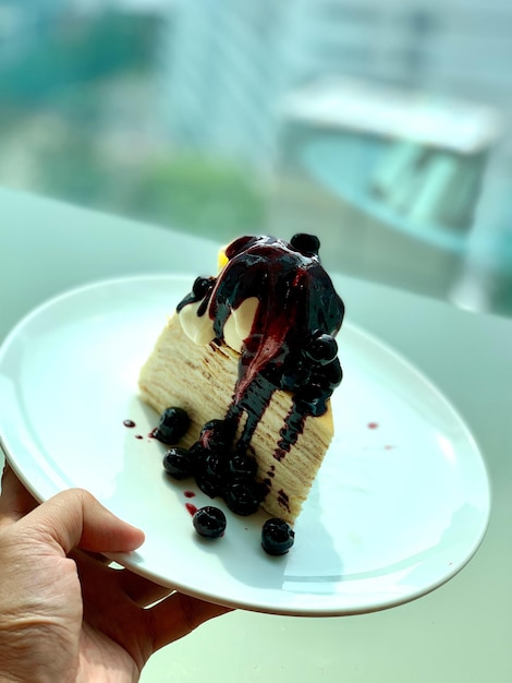 Photo hand holding ice cream cone in plate