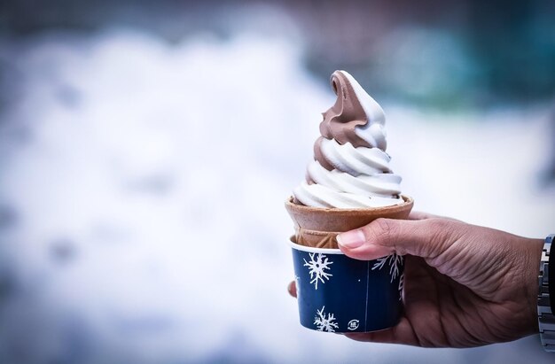 Foto un cono di gelato in mano