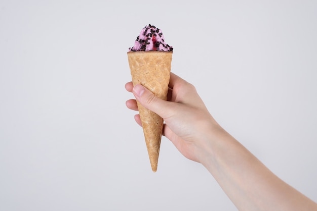 Hand holding ice cream on isolated white background