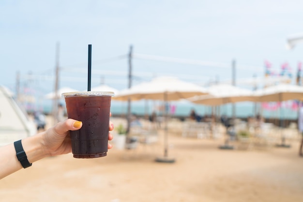 Hand holding iced americano coffee