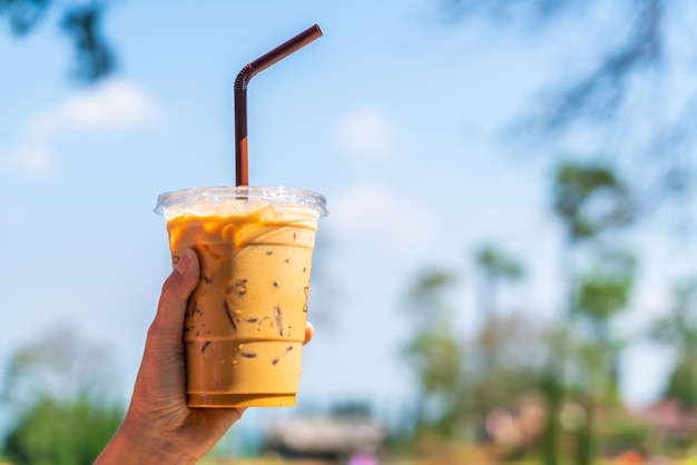 hand holding iced latte coffee cup