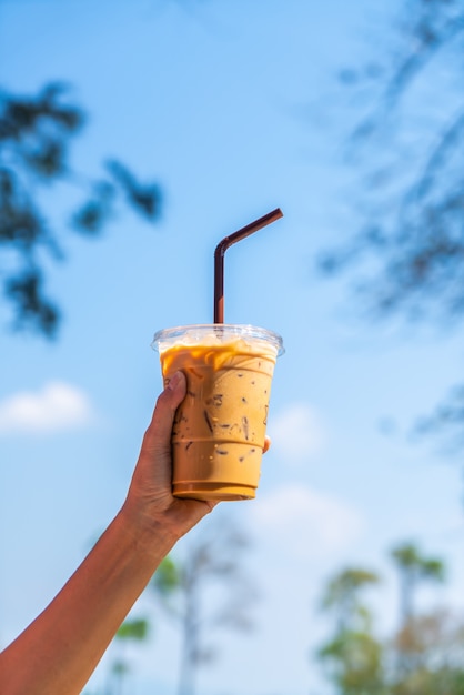 hand holding iced latte coffee cup