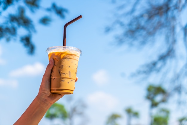 hand holding iced latte coffee cup