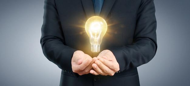 Hand of holding illuminated light bulb, idea innovation inspiration concept