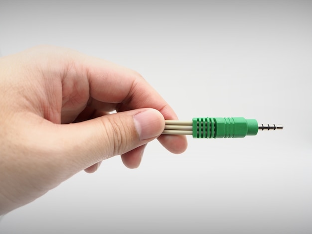 Hand holding a jack instrument cable on a white background.