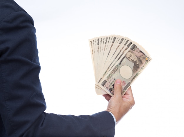 Hand holding Japanese banknote on white background. Japanese money.