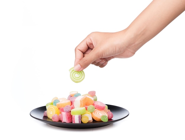 hand holding Jelly sweet on a dish isolated on white background