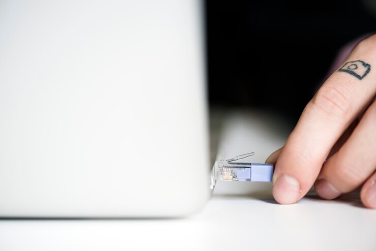 Photo hand holding lan cable connect to laptop