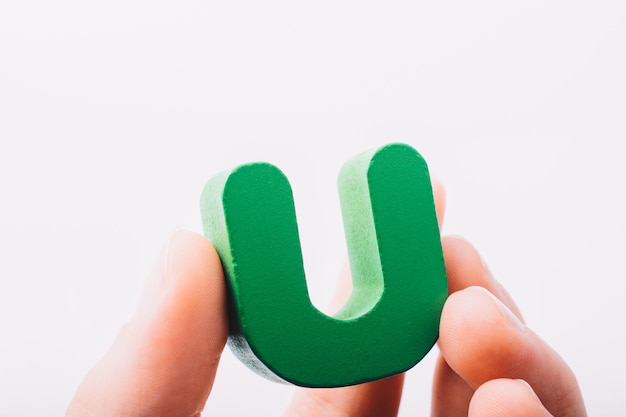 Hand holding letter cube U of made of wood