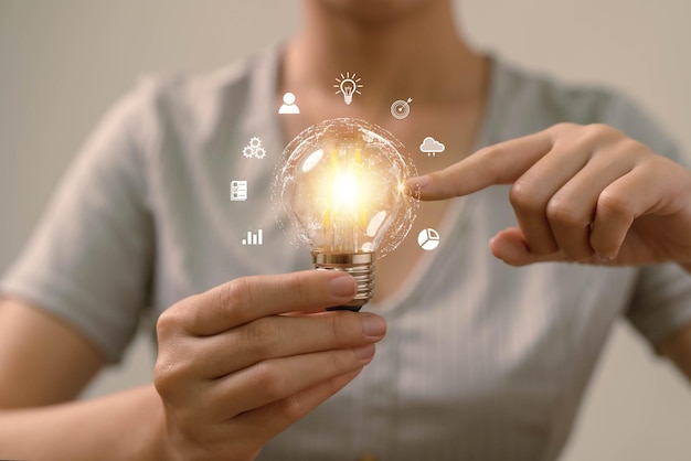 電球を持っている手。創造的なビジネスアイデアの出現や学習を伝える