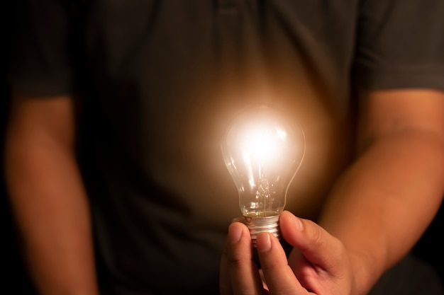 Hand holding light bulb