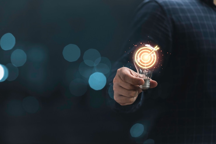 Photo hand holding lightbulb with target board  for creative and set up business objective target  goal concept.
