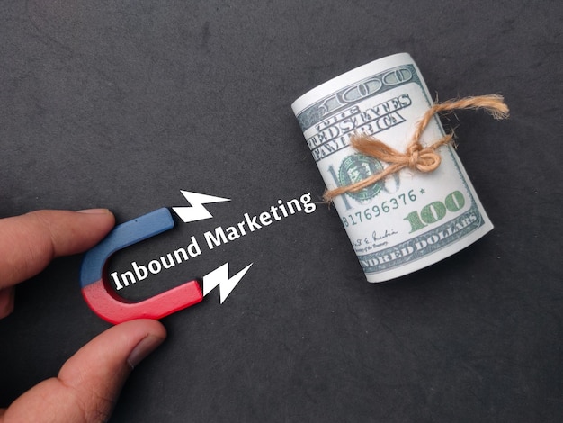 Hand holding magnet to attracts banknotes with word inbound marketing business concept