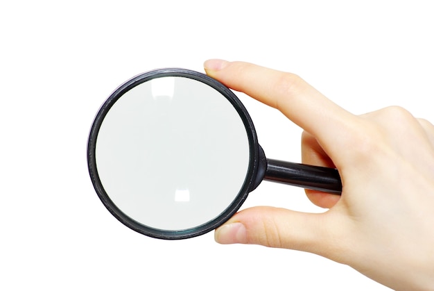 Hand holding a magnifying glass on white