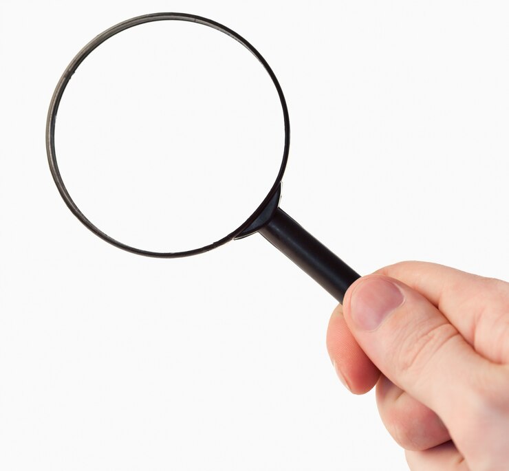 Photo hand holding a magnifying glass