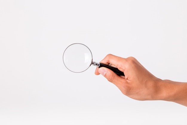 Photo hand holding a magnifying glass