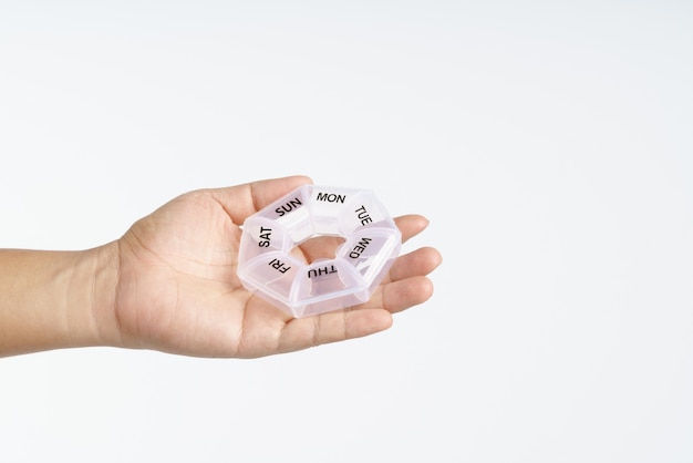 hand holding medicine pills plastic box container