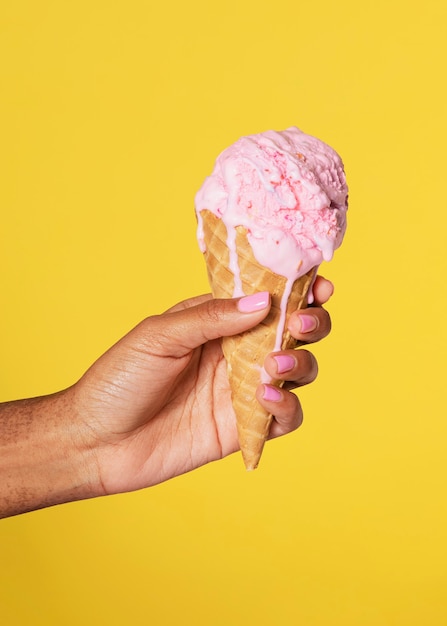 Hand holding a melting ice cream