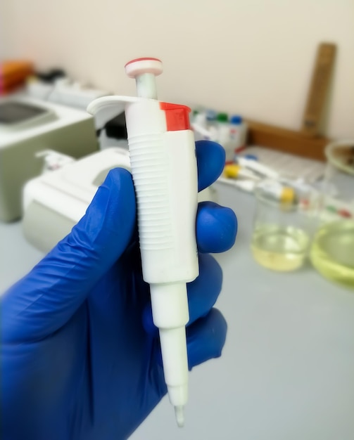 Hand holding micro pipette in laboratory Microliter Pipette