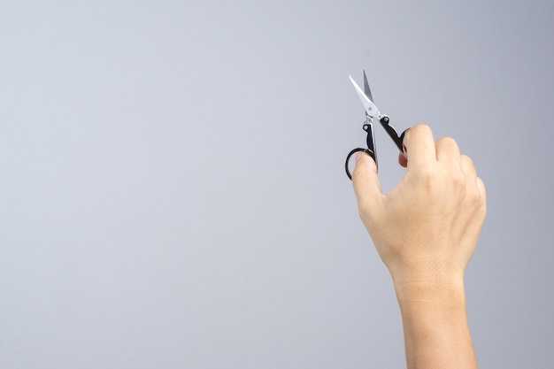 Hand holding mini folding scissors for traveling