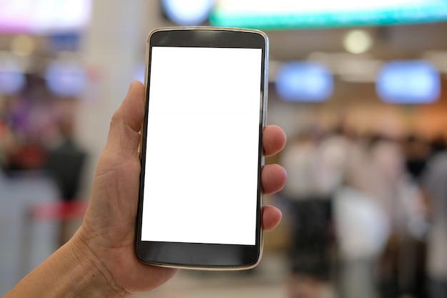 Mano che tiene smartphone mobile all'aeroporto