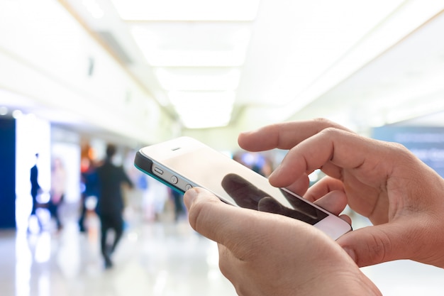 Hand holding mobile smart phone , blurred background