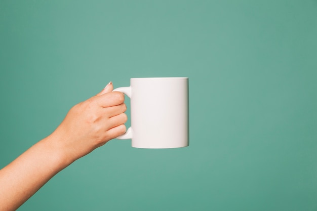 Photo hand holding a mug