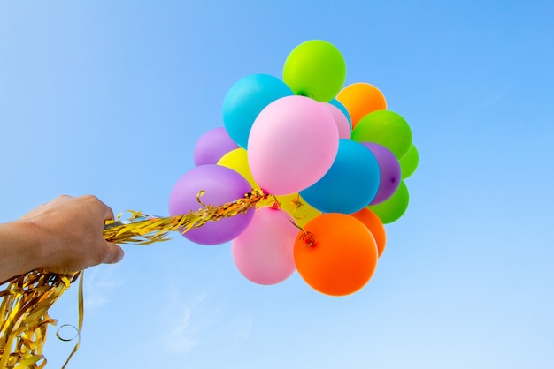 Hand holding multicolor balloons