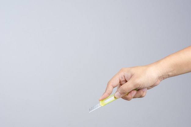 Hand holding office yellow paper cutter