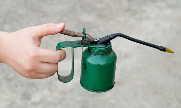 Photo hand holding old and dirty  oil can