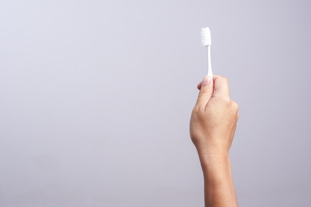 Hand holding old toothbrush