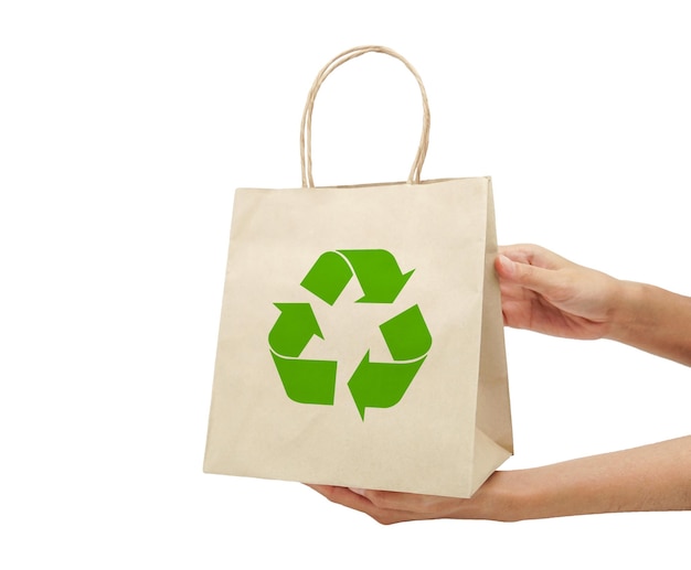 Foto una mano che tiene un sacchetto di carta con un simbolo di riciclaggio su di esso