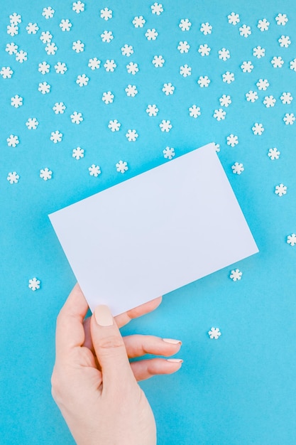 Photo hand holding paper over blue background