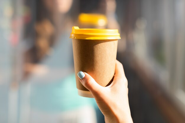 Photo hand holding paper cup of coffee