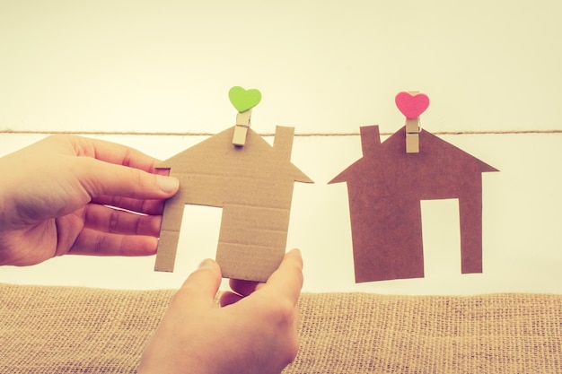 Photo hand holding a paper house on canvas