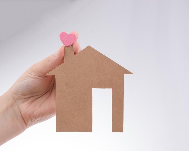 Hand holding a paper house on canvas